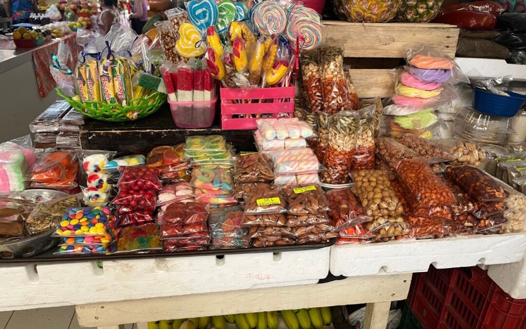 Candy and fruit on a colorful Mexican market. There are banana lying on the lower floor and nuts and chili flavored sweets on the top