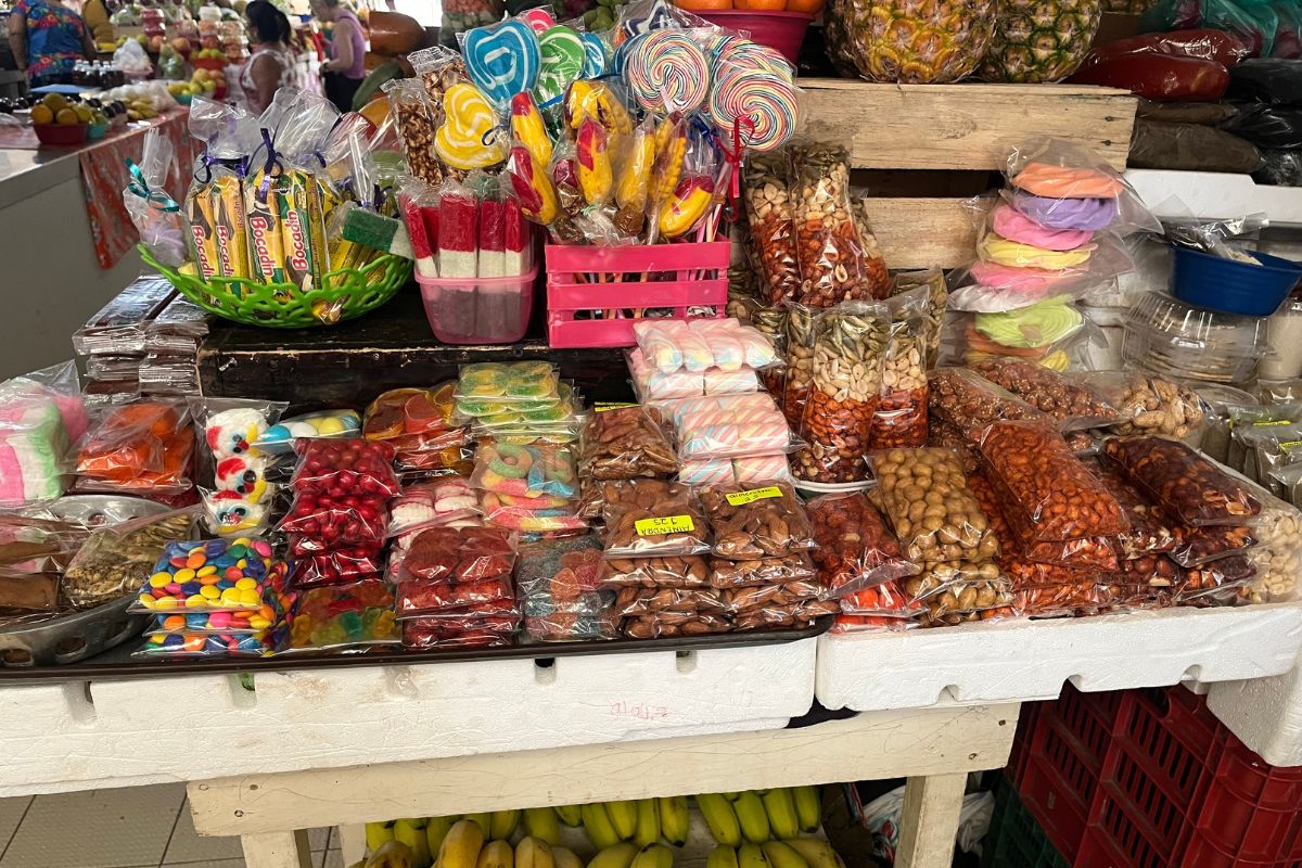 Candy and fruit on a colorful Mexican market. There are banana lying on the lower floor and nuts and chili flavored sweets on the top